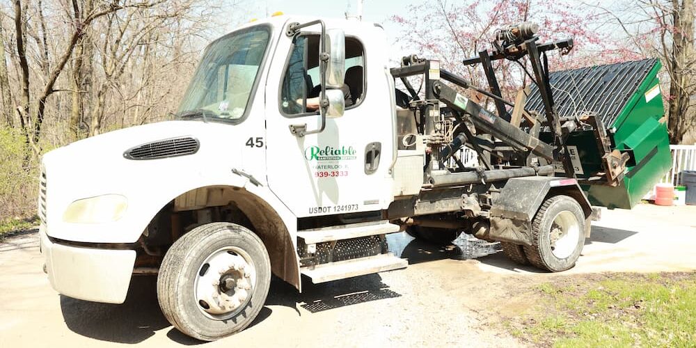 Garbage truck picking up commercial dumpster